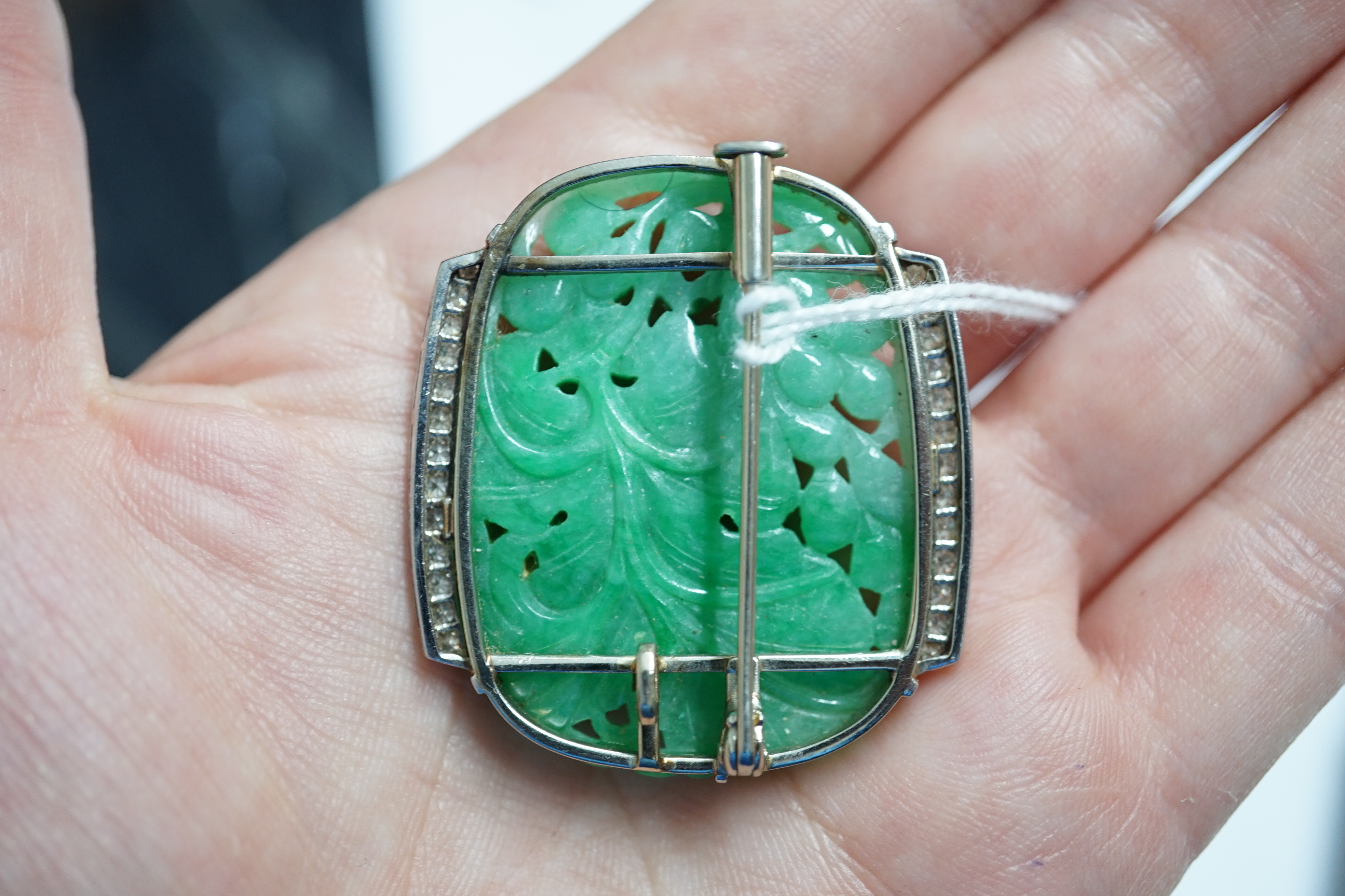 A Chinese white gold and diamond cluster set carved jade leaf and fruit brooch